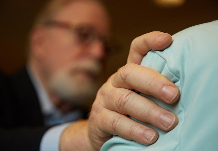 A chaplain puts comforting hand on a patient’s shoulder