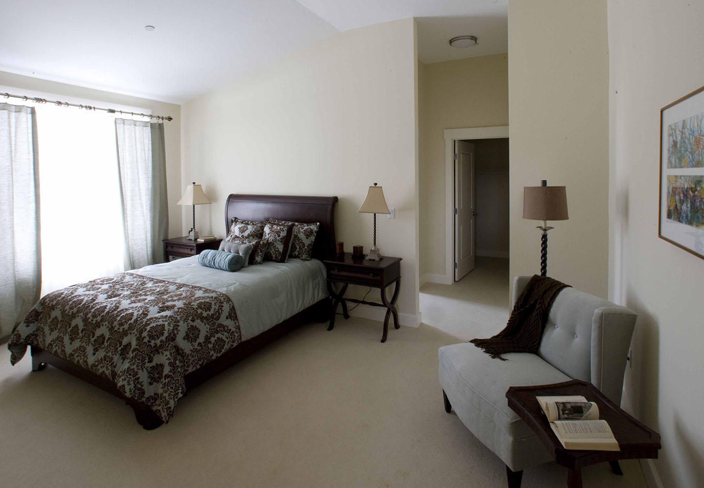 A sunny bedroom with additional seating is typical of NewBridge on the Charles apartments.