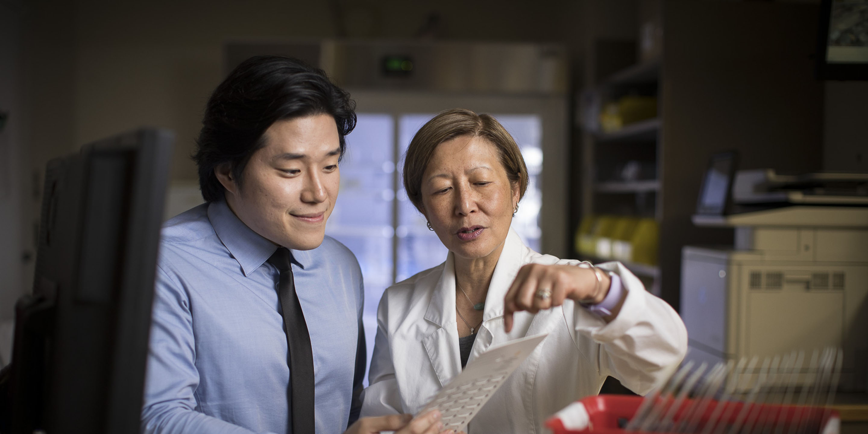 A female pharmacist and a male pharmacy student standing in the pharmacy at Hebrew Rehabilitation Center in Boston.