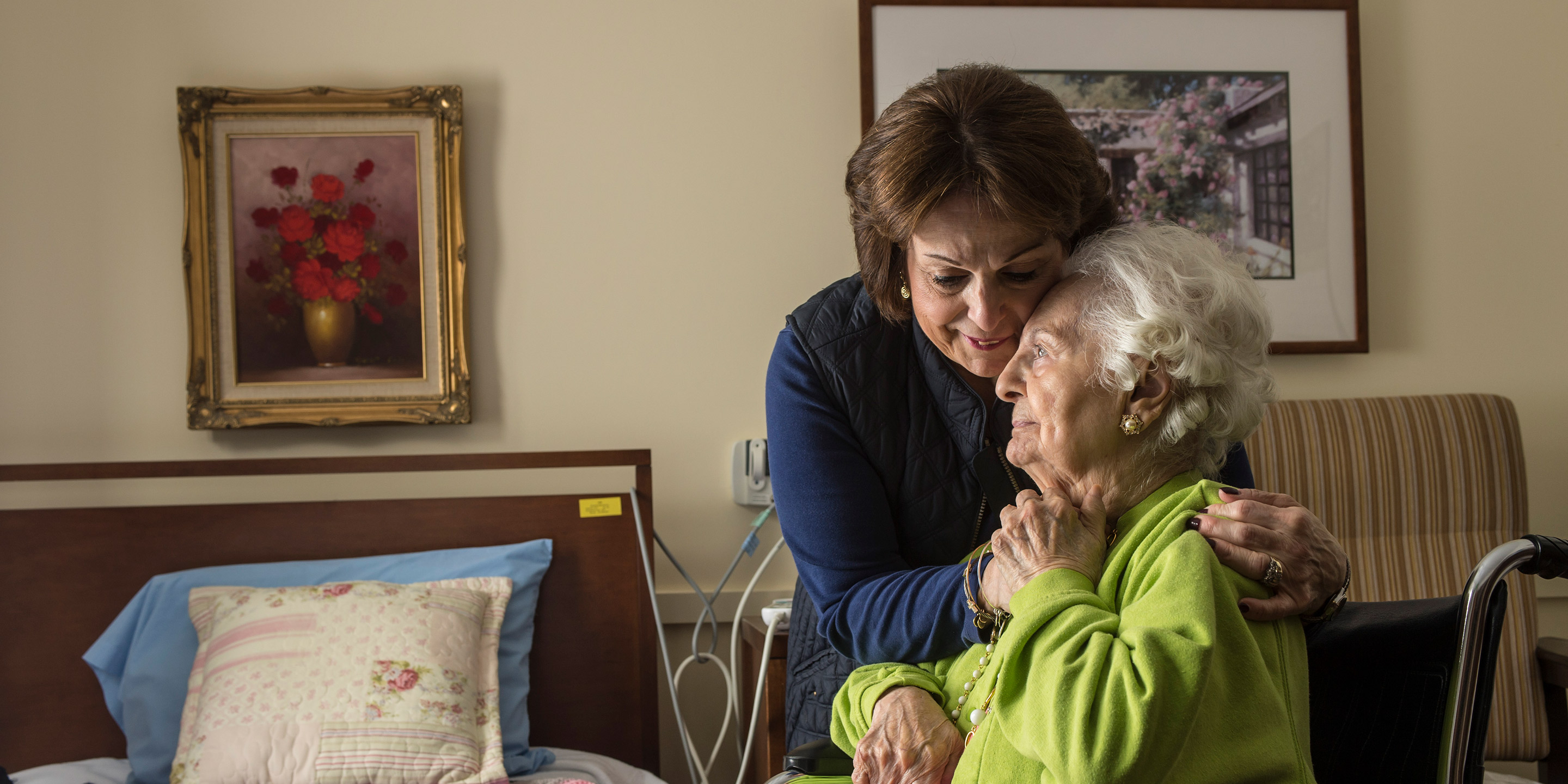 A long-term chronic care patient of Hebrew Rehabilitation Center at NewBridge on the Charles shares a hug with her adult daughter.