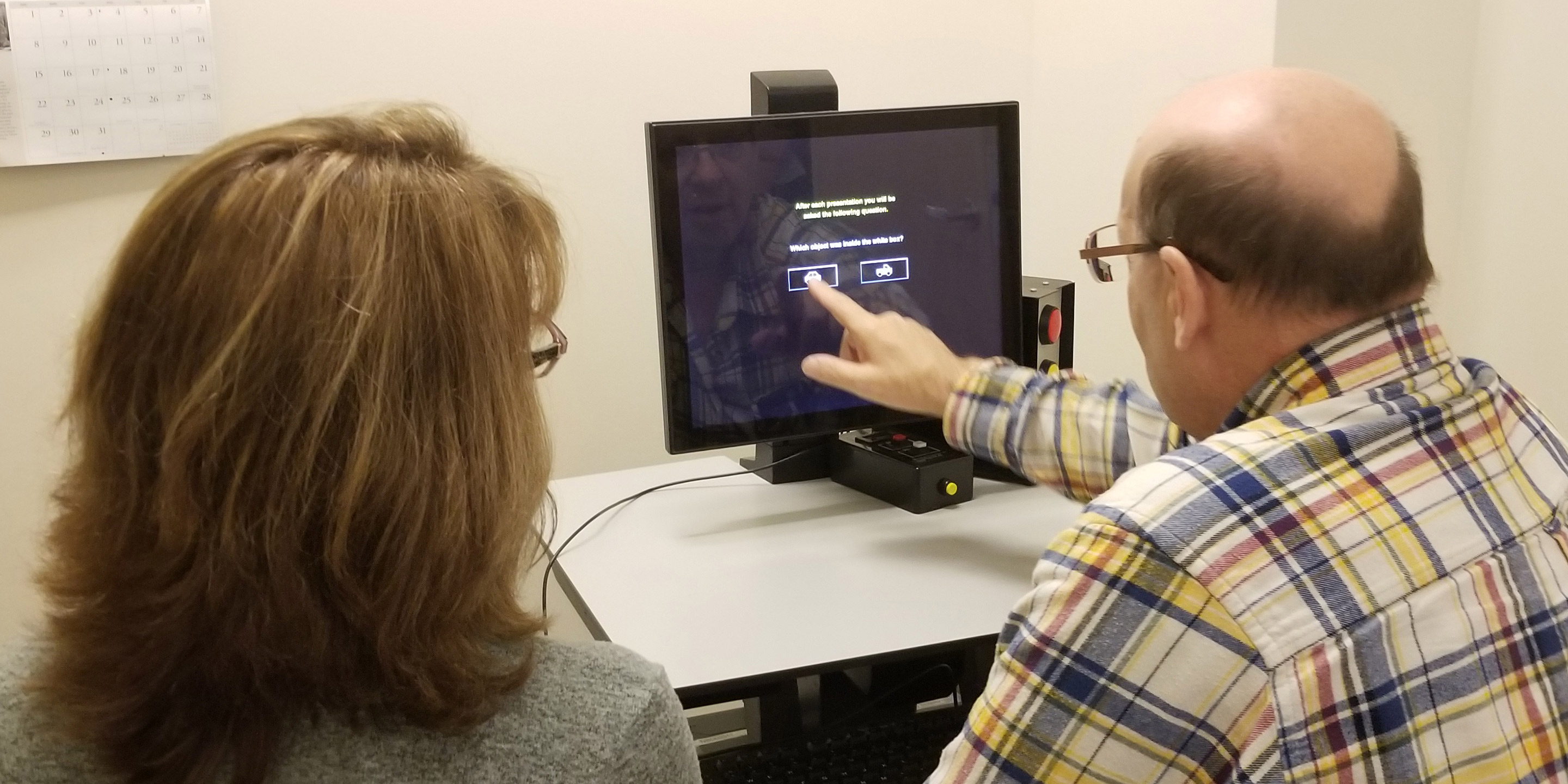 A man sits next to a woman to take a Safe Driving Consultation on a computer