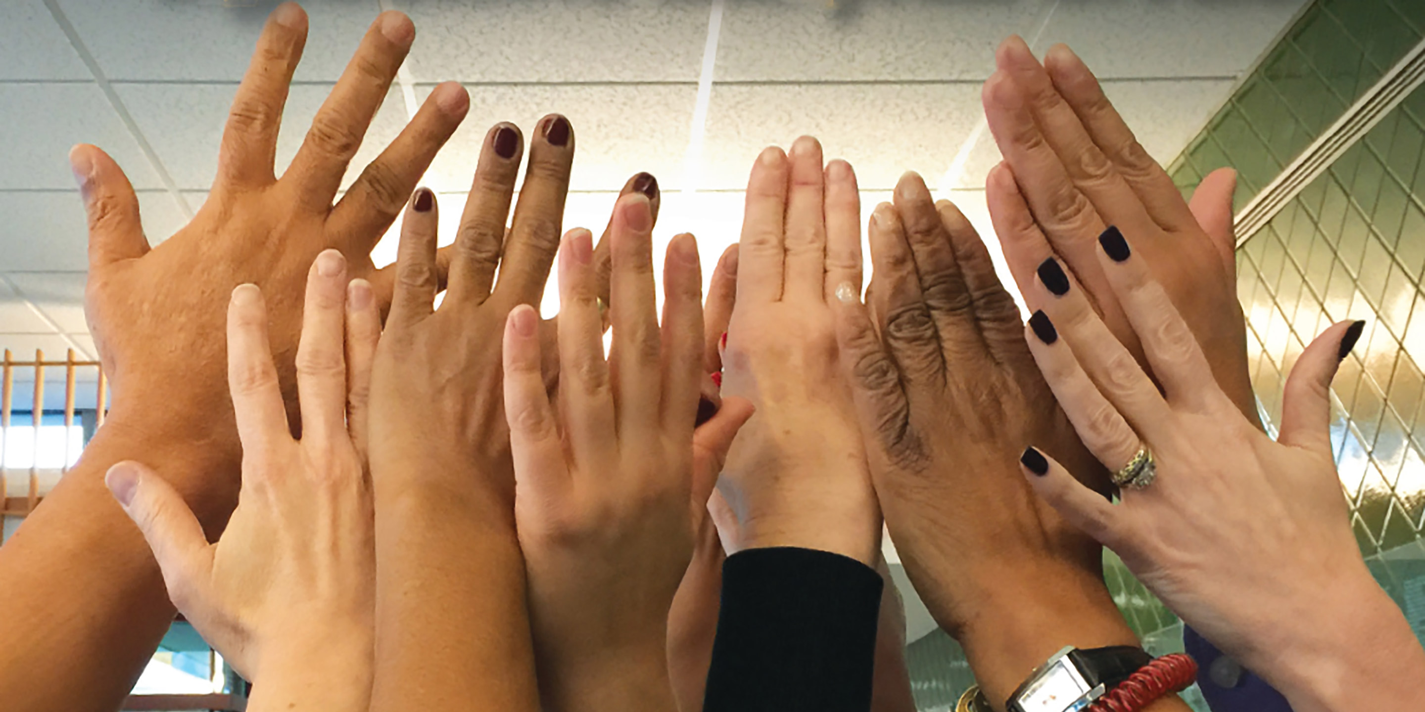 A group of people raise their hands in the air