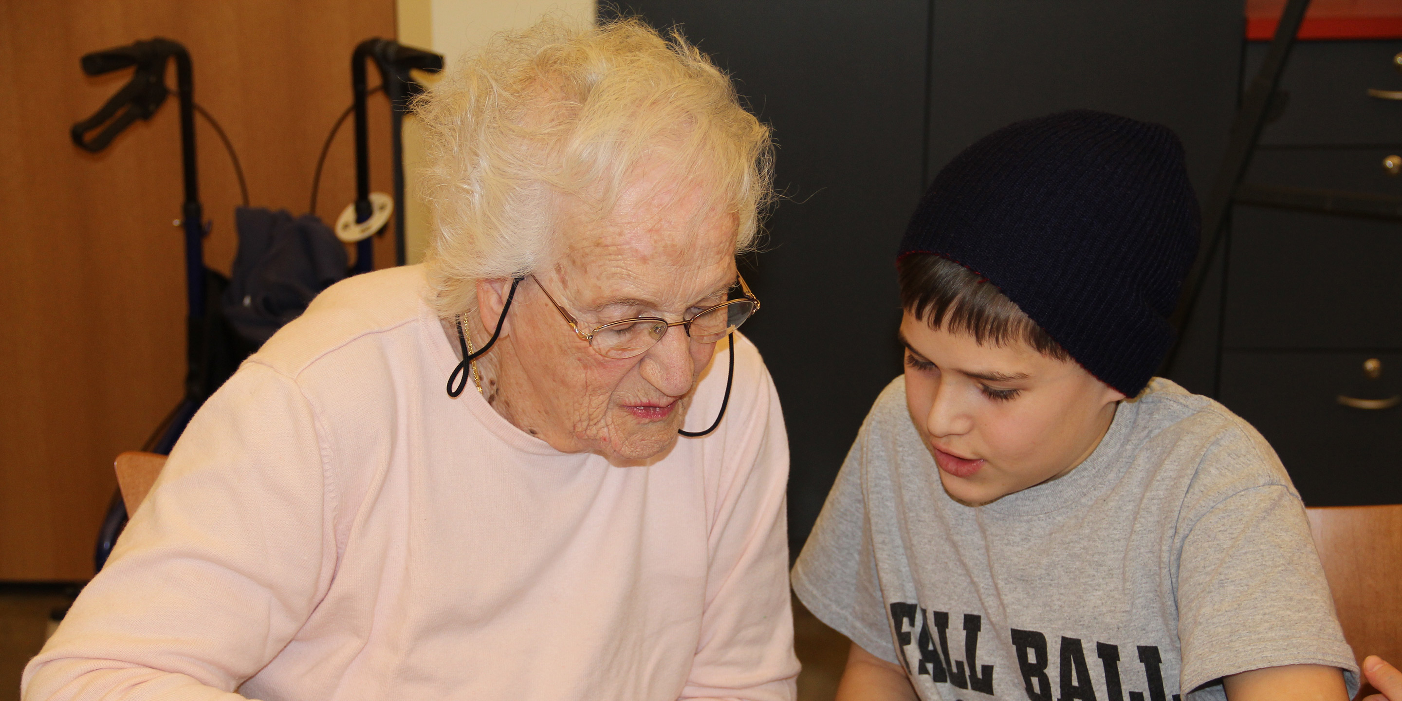 A resident and a child look down together at an IPad