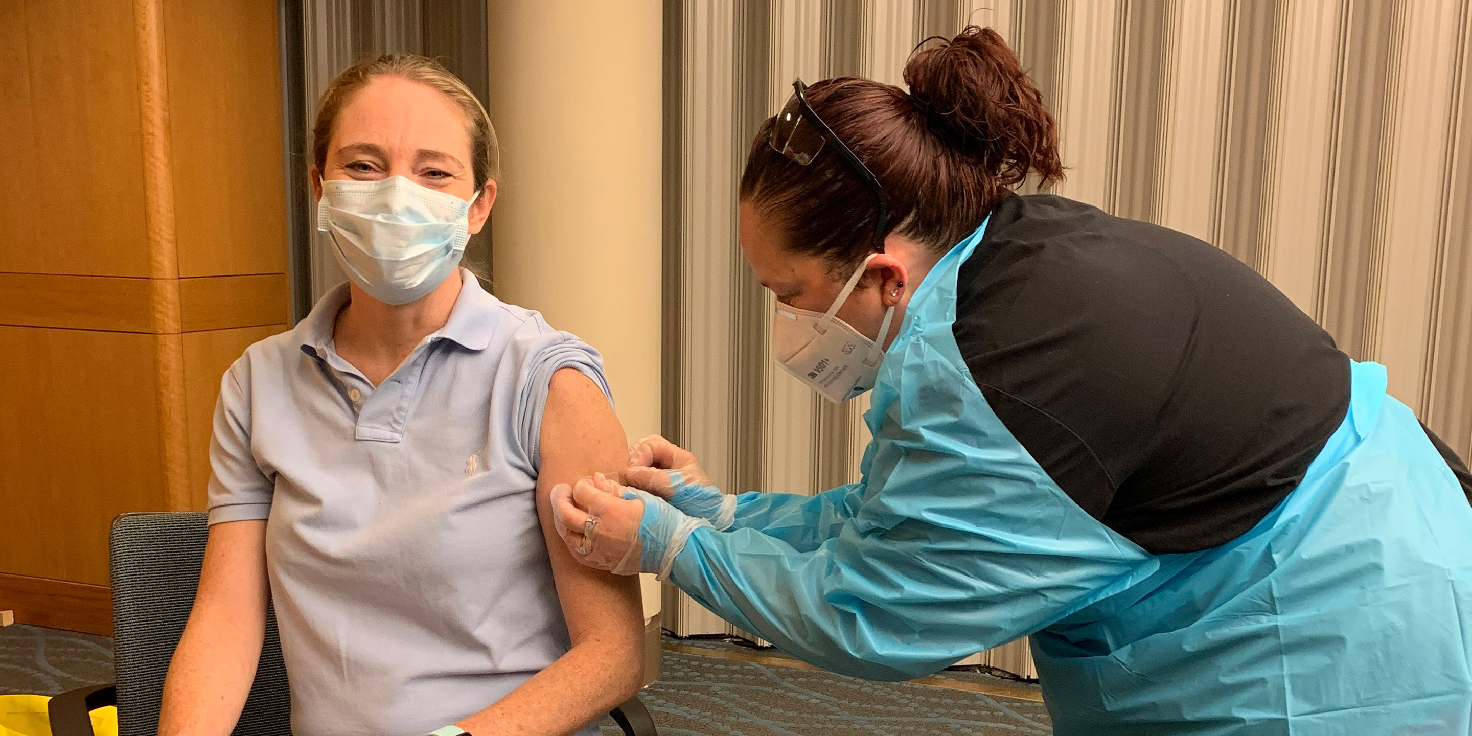 A HSL employee smiles while she receives a flu shot.