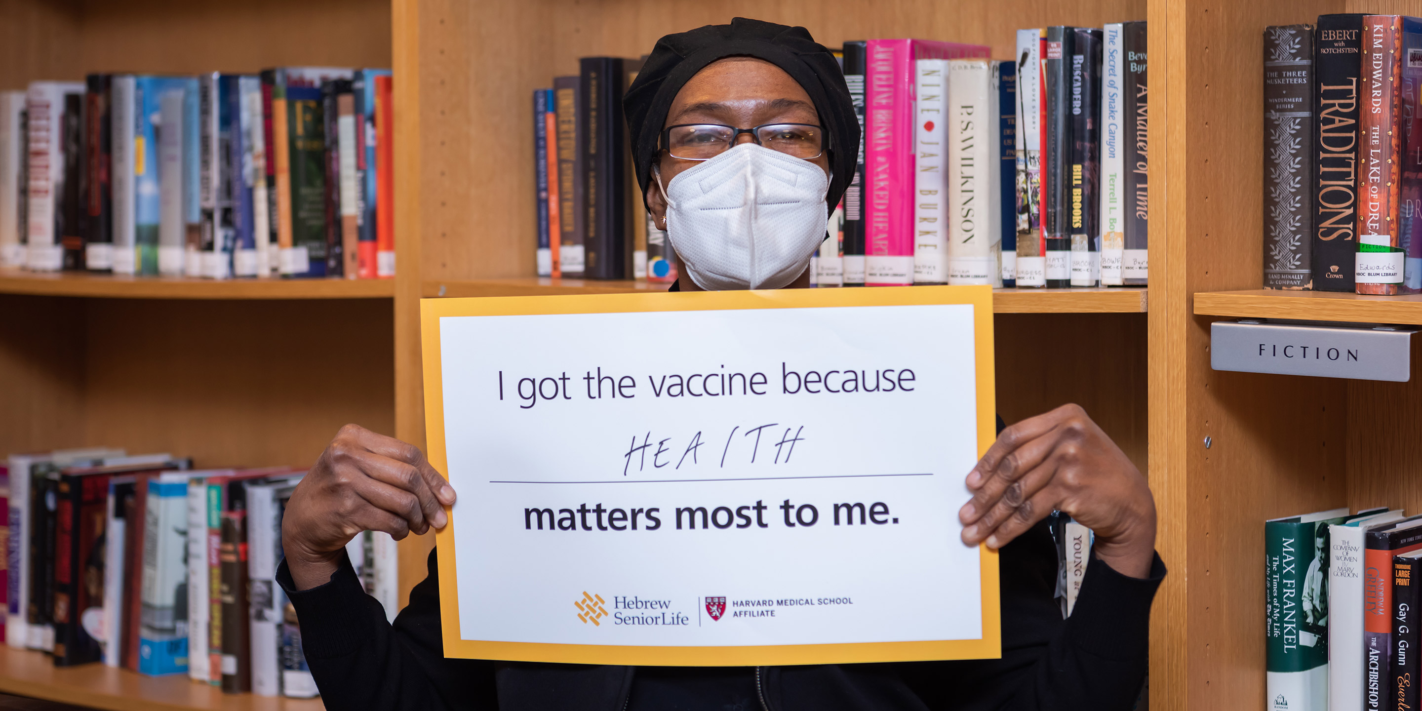 A recipient of a COVID-19 vaccine at HSL holds up a sign saying what matters most.