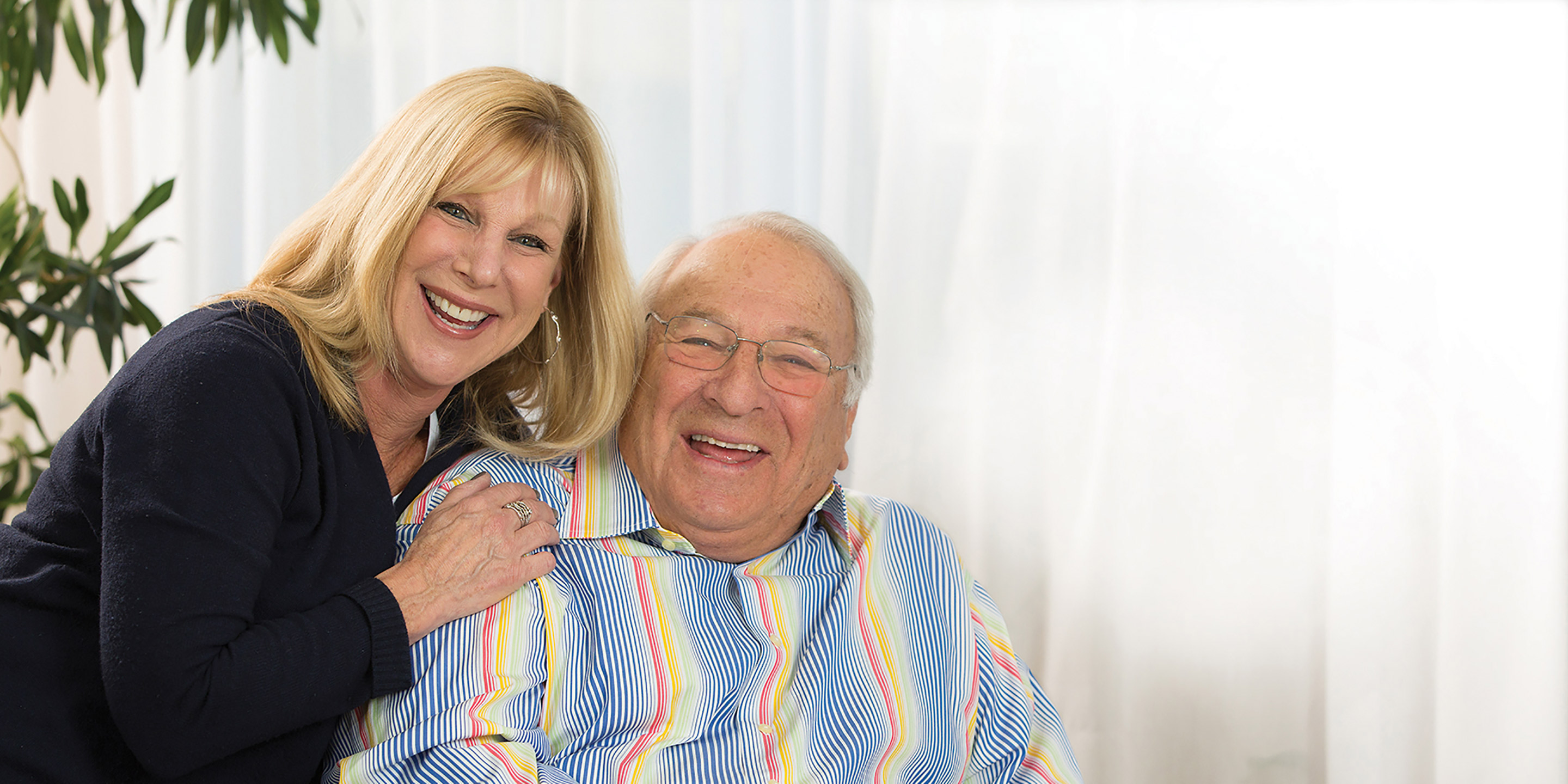 A female life care manager smiles with an older male.