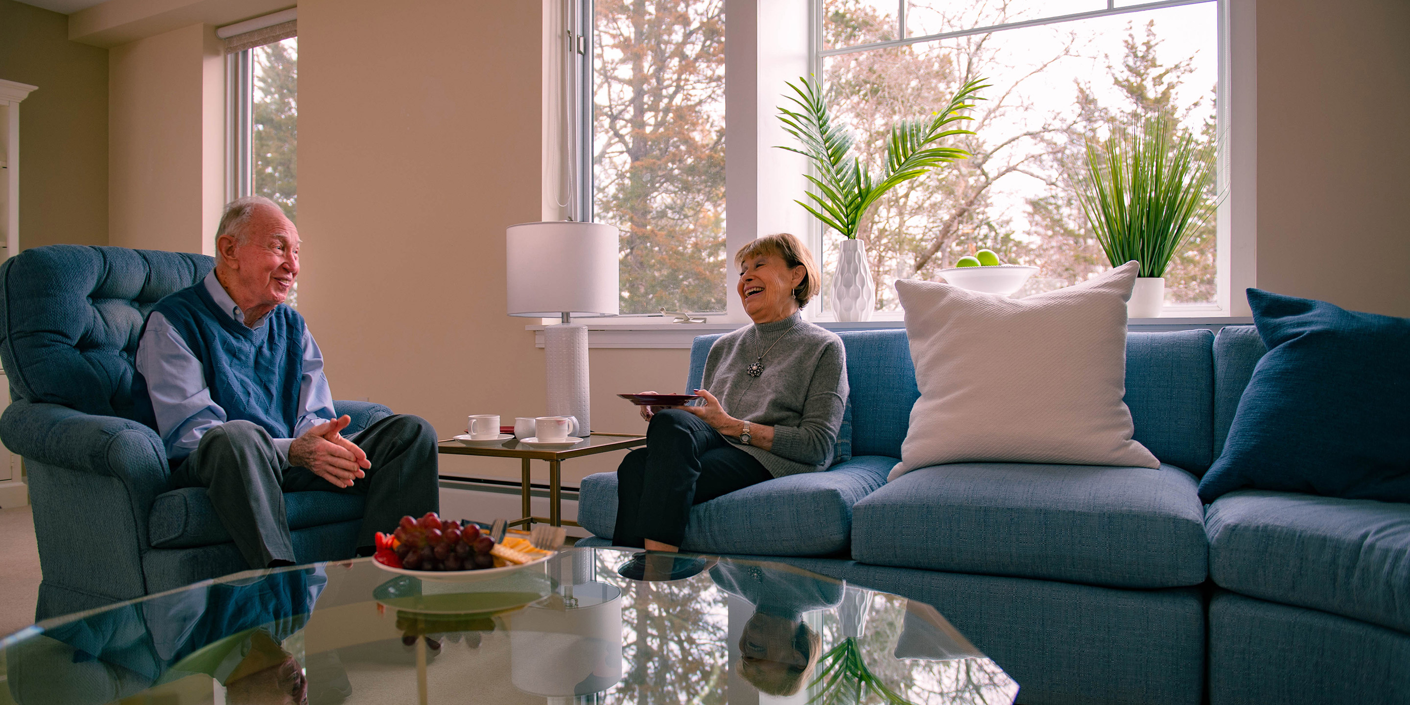 Two residents sit and laugh together.