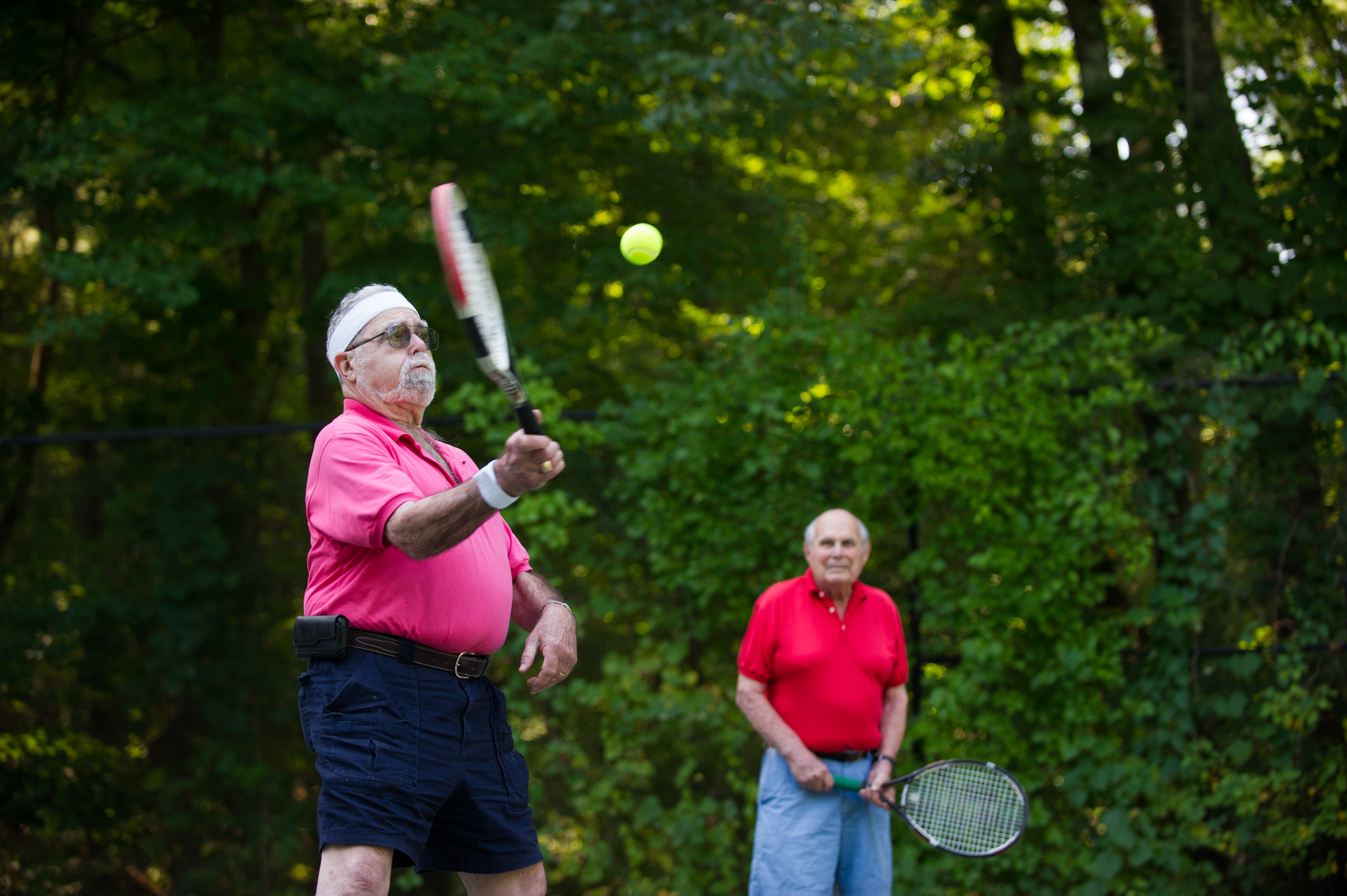 Two men playing tennis outdoors