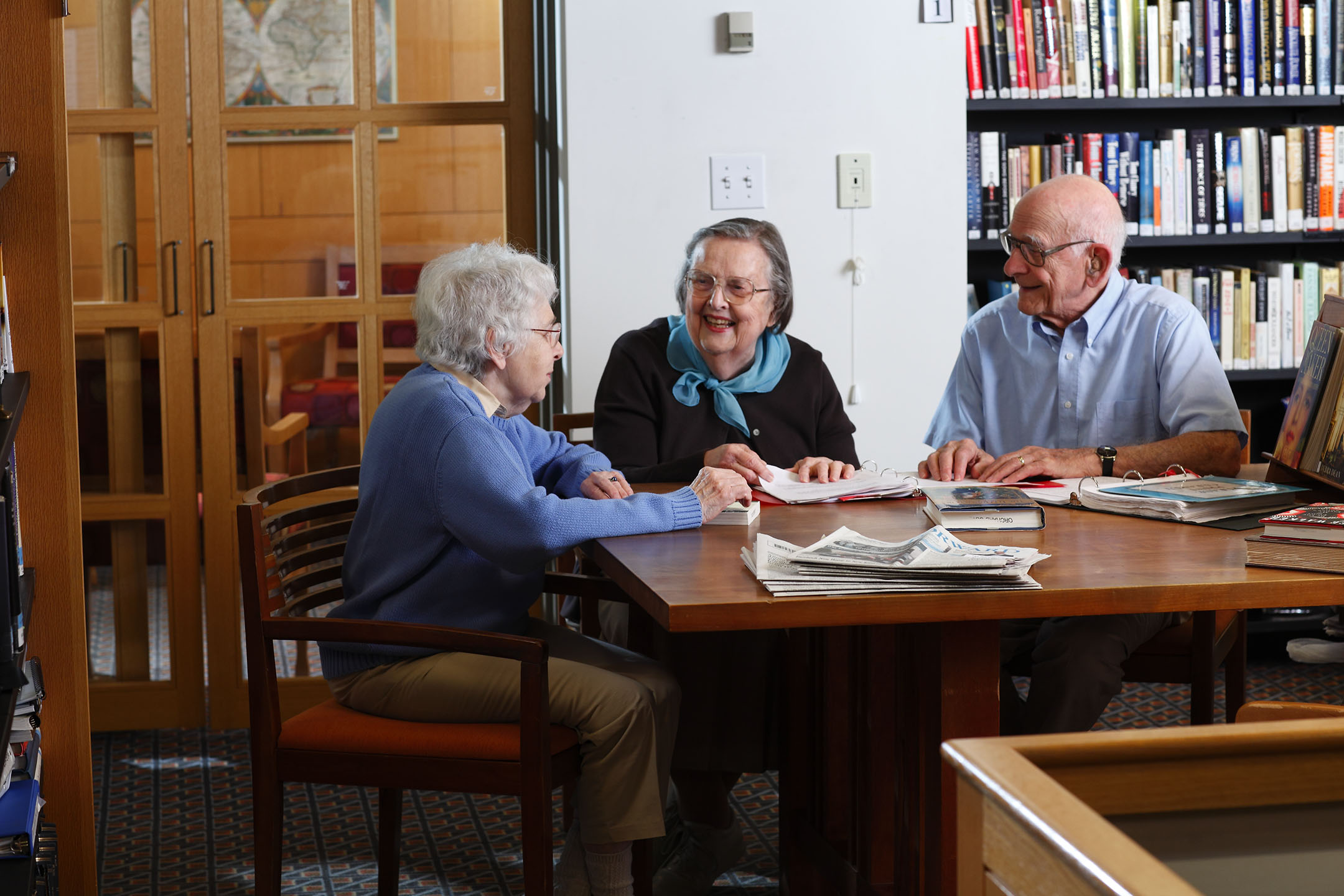 Group of senior citizens having a discussion in a library.