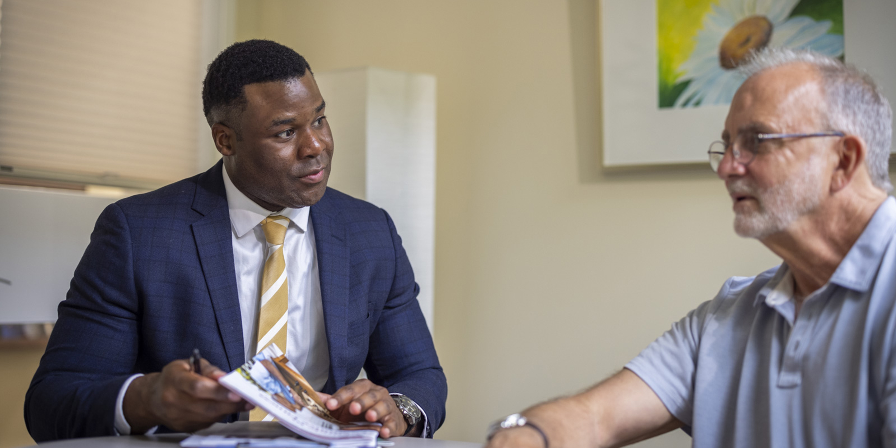 A psychiatrist at Hebrew SeniorLife’s Wolk Center for Memory Health in Boston sits at a table talking to a patient.