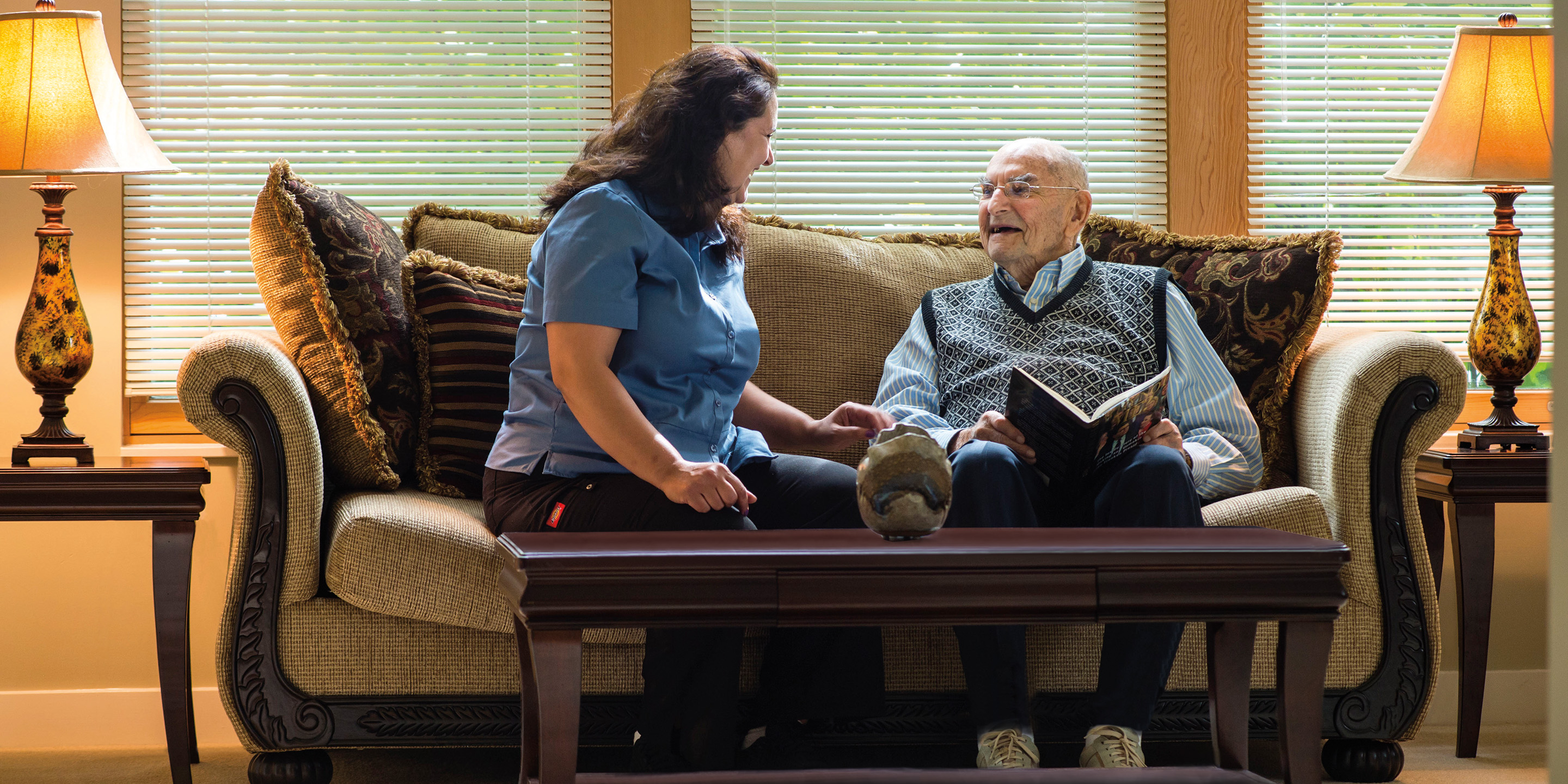 Woman sitting with senior man on couch