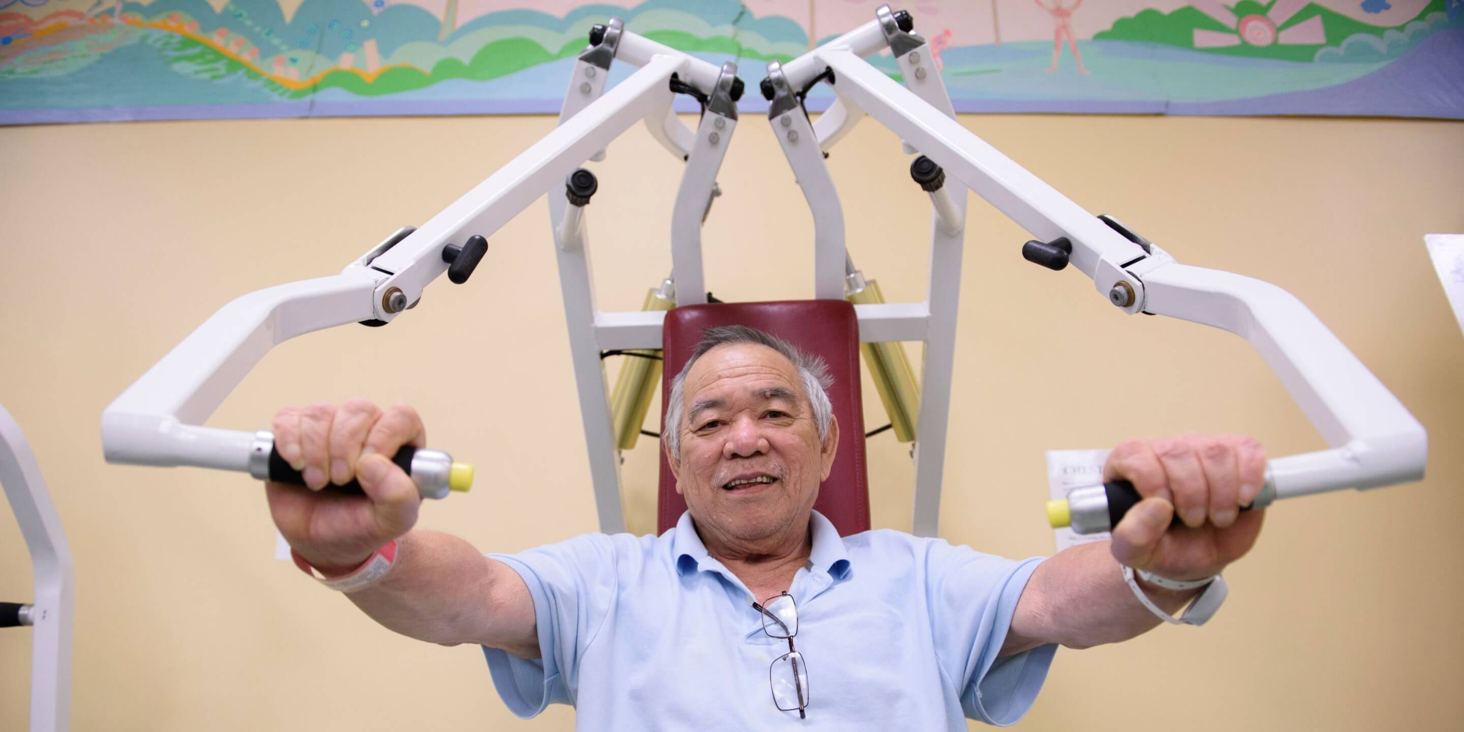 Older man using weight training machine