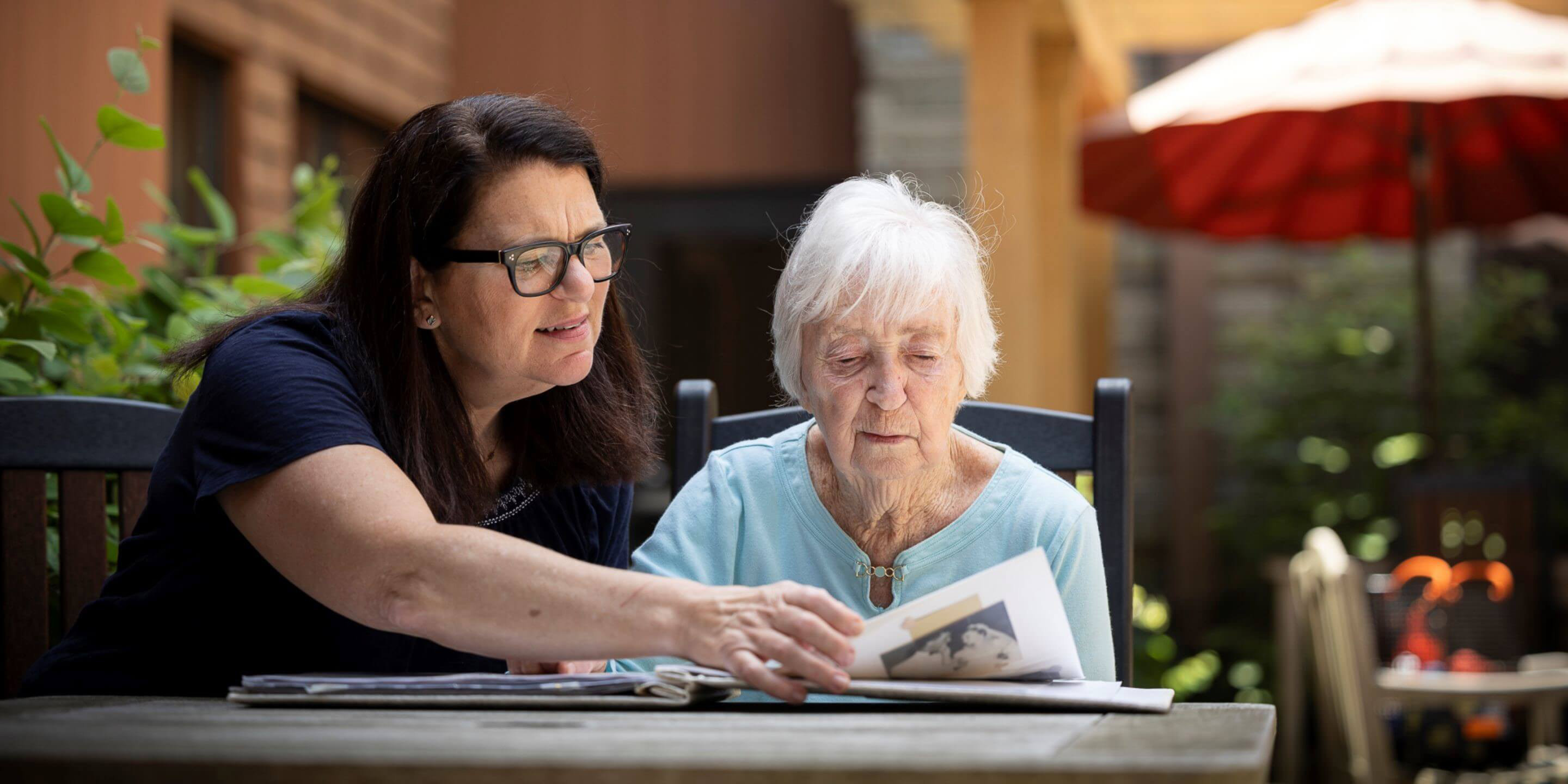 Older woman sitting outside with another woman