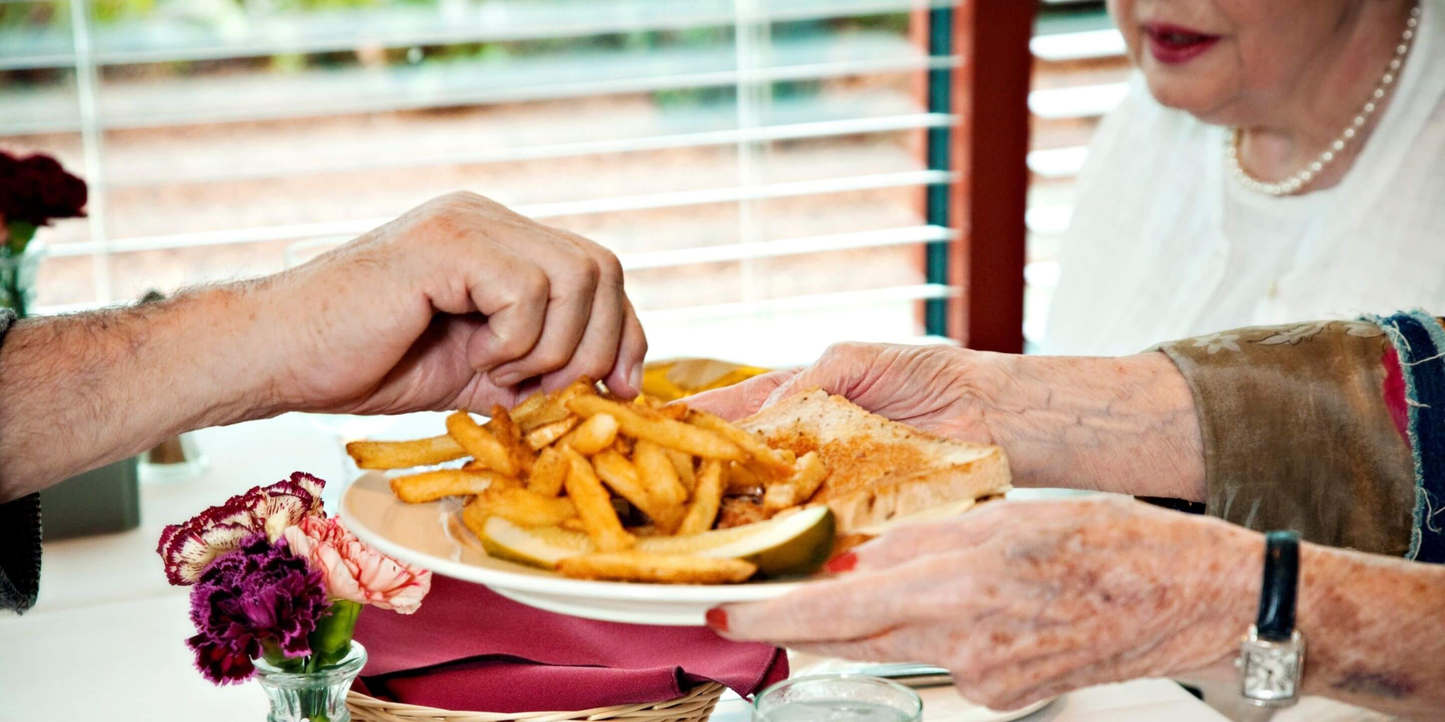 Photo of older people sharing a plate of fries