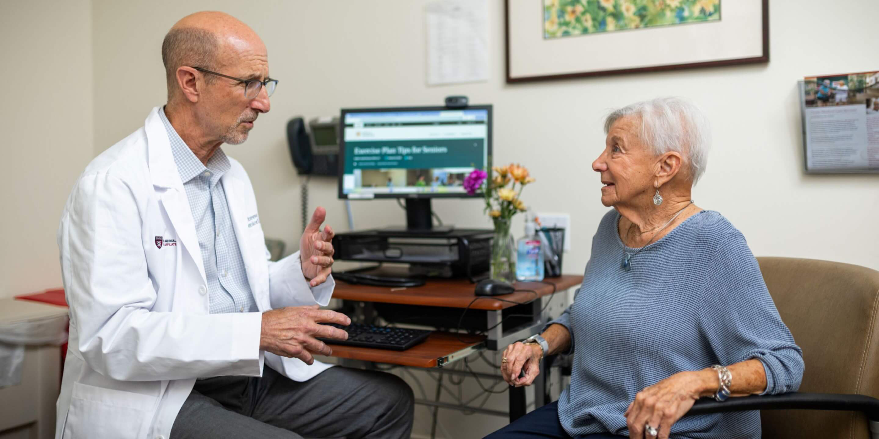 Male doctor sitting with an older woman discussing care