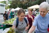 Two women pick out vegetables at a Farmer's Market 