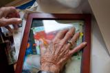 A woman wearing a ring places her hand over a picture frame 