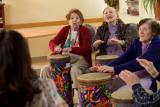 Residents at Hebrew SeniorLife participate in a music therapy activity involving drums