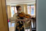 NewBridge on the Charles employee, Leticia Alvaraz, plays a violin while wearing a face mask during the COVID-19 coronavirus pandemic 