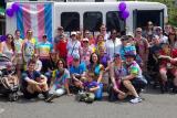 A group of HSL employees and residents stand in front of a bus at the Boston Pride Parade 