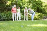 Four female residents play bocce ball outside 
