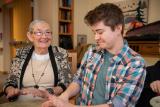 Two volunteers play drums with a female resident