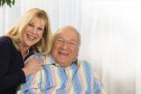 A female life care manager smiles with an older male.