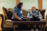 Woman sitting with senior man on couch