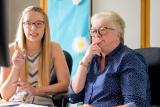 Younger woman and older woman sitting at desk discussing work