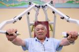 Older man using weight training machine