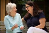 Middle-aged woman sitting with older woman