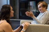 Younger woman sitting with an older woman whose talking.
