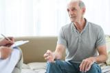 Older man sitting down with a doctor talking.