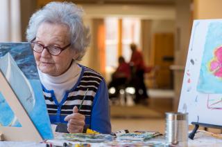 A female resident paints a photo.