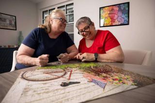 Two older women working on a puzzle