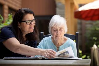 Older woman sitting outside with another woman