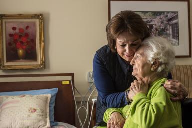 A long-term chronic care patient of Hebrew Rehabilitation Center at NewBridge on the Charles shares a hug with her adult daughter.