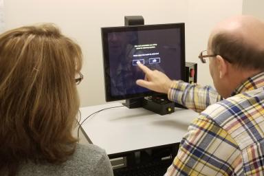 A man sits next to a woman to take a Safe Driving Consultation on a computer