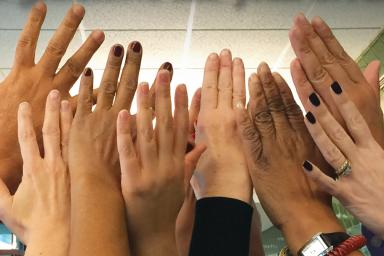 A group of people raise their hands in the air