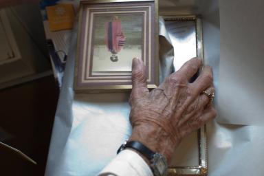 A woman places her hands over a few picture frames.