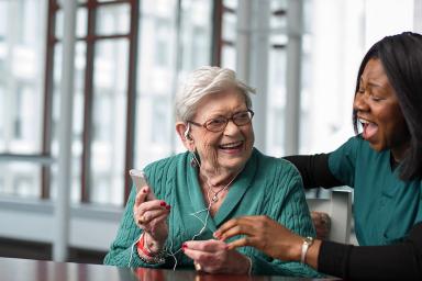 Rehabilitation Center listens to therapeutic music with the help of a life enhancement team member.