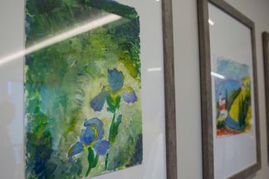 A hallway filled with colorful resident paintings 