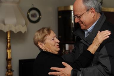Hebrew SeniorLife's CEO Lou Woolf goes in for a hug with a female senior 