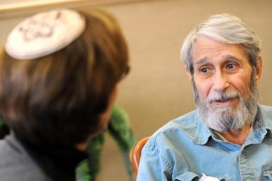 Female Rabbi has a serious conversation with older man with a beard.