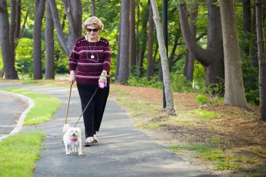 Woman walking outside with her dog.