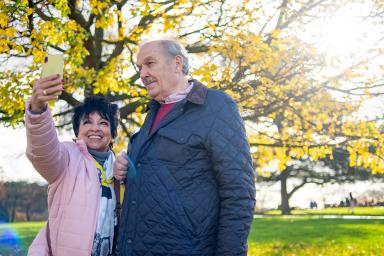 senior couple outside taking a photo