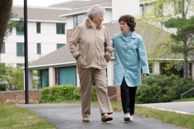Two older women walking together outside