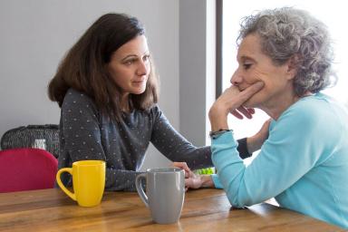 Adult woman sitting with older mother