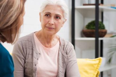 Older woman sitting with another woman