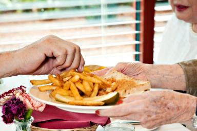 Photo of older people sharing a plate of fries